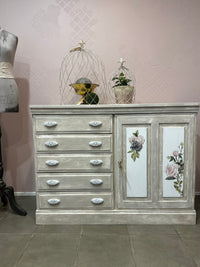 Using the Chateau method layering paint and wax has created this unique Olde Worlde look on this solid sideboard. Shades of grey, white and floral transfers complete the look, Dimensions approx 900mm height x 1200mm length.