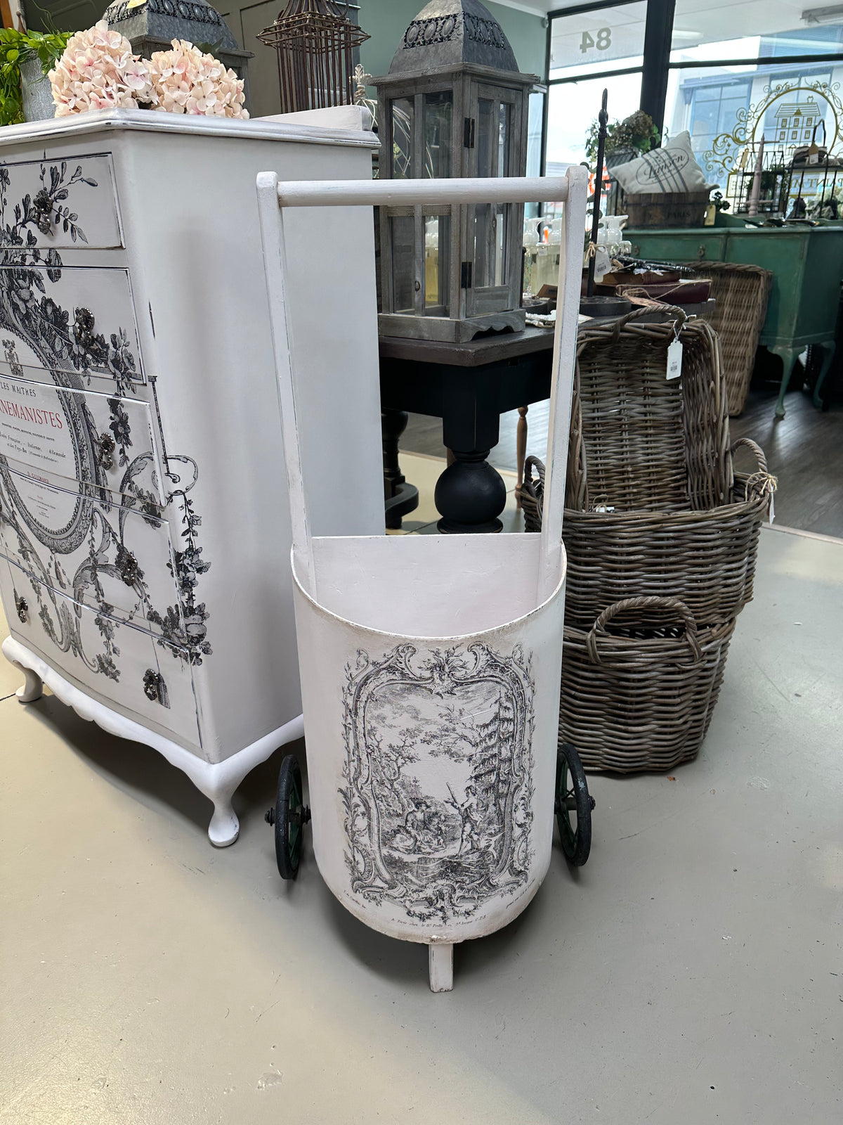 This is a very old trolley and we suggest it is used as a decor and display item only. It is not fit for travelling the pavement. Revamped using the softest of pinks Old Chiffon and our toile paint inlay. She looks perfect filled with flowers.